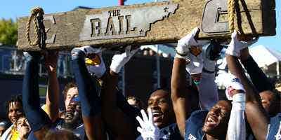 Members of UTC's football team hoist "The Rail" after beating ETSU in the "Rail Rivalry" 21-16 in 2021